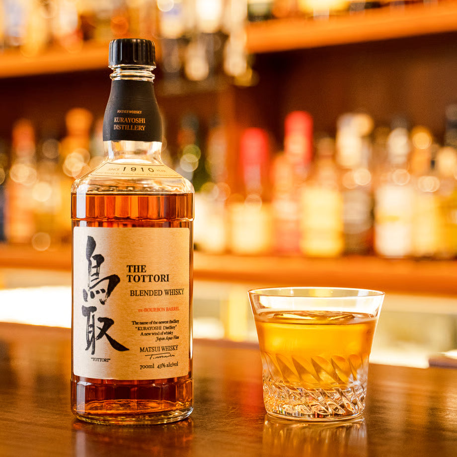 マツイブレンデッドウイスキー「鳥取 金ラベル」のボトルとロックグラスが並ぶ写真。モルトとグレーン原酒を合わせ、バニラのような甘い香りが広がるウイスキー。
